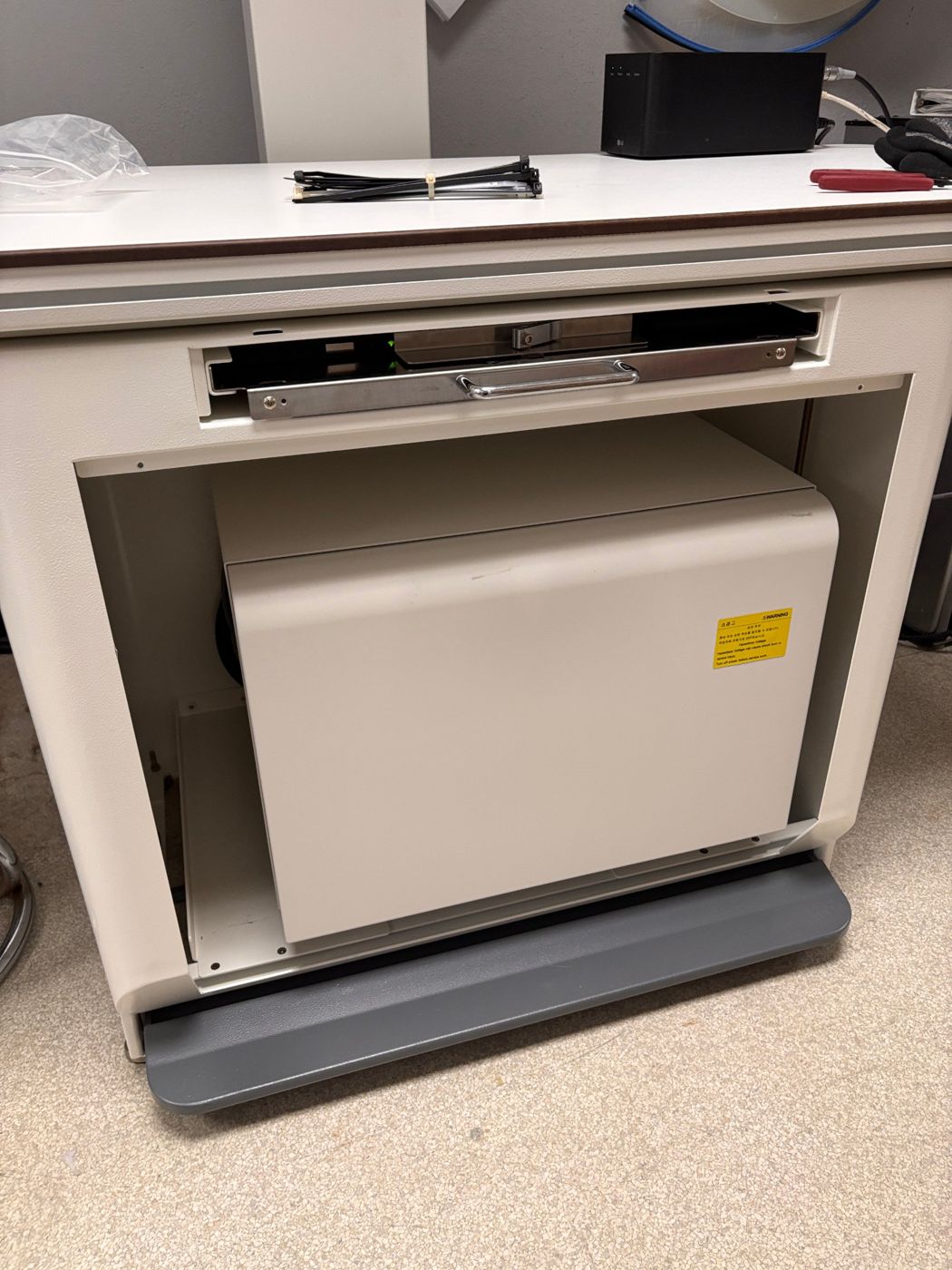 Table base opened to show the built-in generator and detector tray